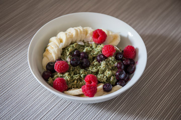 Matcha  Oatmeal porridge with ripe berries and banana