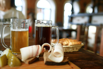 Fototapeta na wymiar two beer mugs in a Czech beer restaurant / light and dark beer in large mugs traditional Prague pub