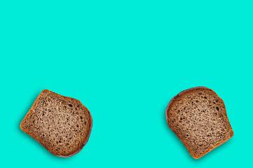 Two rectangular pieces of fresh rye bread on green table on kitchen. Copy space for your text. Top view. Dieting concept