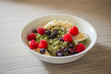 Matcha  Oatmeal porridge with ripe berries and banana