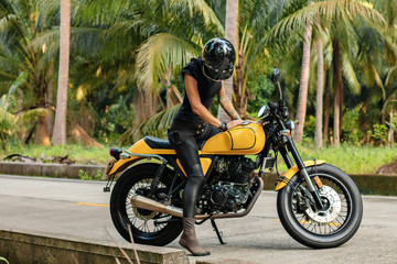 Fototapeta na wymiar girl at sunset near the motorbike in jungle