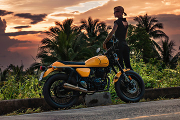 girl at sunset near the motorbike