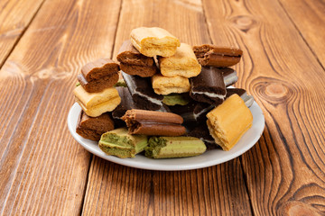 side view broken multicolor sandwich cookies on a wood table