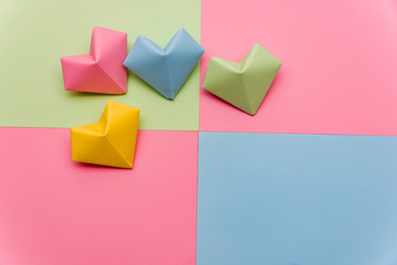 Heart shape made of torn pieces of colorful paper isolated over the origami paper hearts