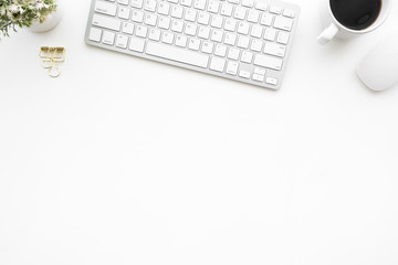 White office desk table with computer supplies and cup of coffee. Top view with copy space, flat lay.