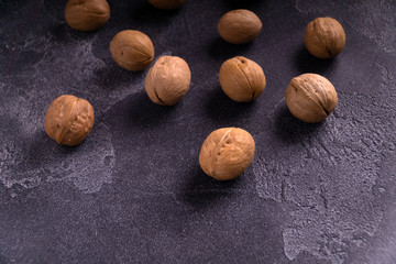Bunch of whole walnuts on dark blue slate background. Healthy diet composition, background