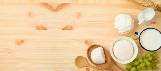 Milk and cheese, dairy products on wooden table background.