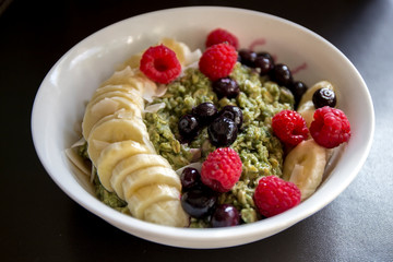 Matcha  Oatmeal porridge with ripe berries and banana
