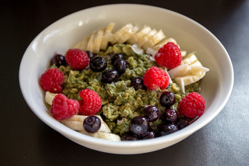 Matcha  Oatmeal porridge with ripe berries and banana