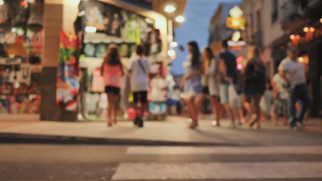Shopping street in the tourist resort town of Catalonia Calella with tourists. Blurred view.