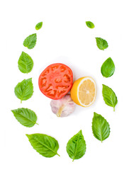 Composition of basil leaves of tomato, garlic and lemon on a white background