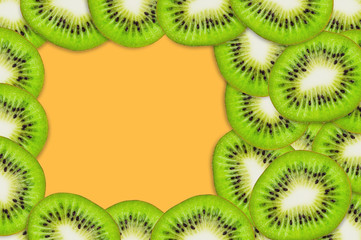 Fototapeta na wymiar Frame with pieces of sliced tasty beautiful ripe fresh kiwi fruit on orange table in kitchen. Top view. Cooking concept. Copy space for your text