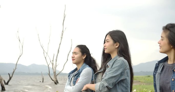 SLOW MOTION - Group of young asian girls enjoying and relaxing at sea or lake together. camping, travel and friendship Concept.