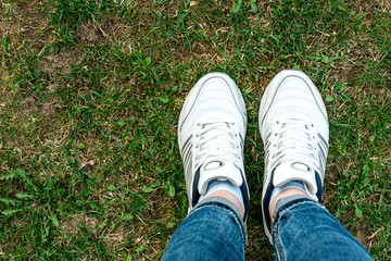 White sneakers on grass background. Healthy lifestyle. Sport.