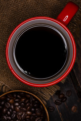 dark coffee in red cup on wooden table