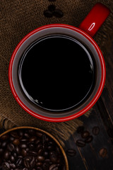 dark coffee in red cup on wooden table