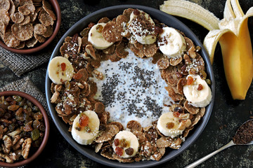 Healthy breakfast bowl with yogurt and chia, cereal, raisins, banana, walnut and seeds. Superfoods Energy food. Keto diet.