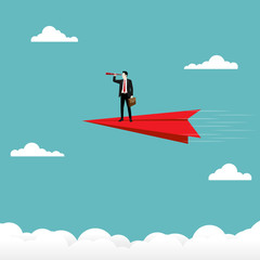 Obraz premium Businessman holding a binocular stand on red paper plane