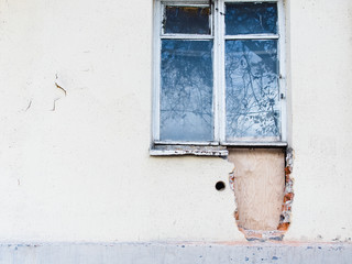  Photo of the outer wall of the building in the process of reconstruction of the window opening. the hole in the wall is covered with plywood sheet