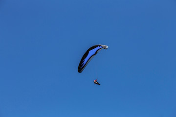 Paraglider flying in cloudy sky