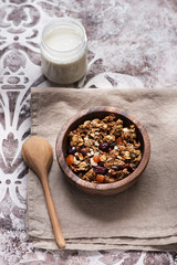 granola muesli with dried fruits and seeds and a jar of yogurt