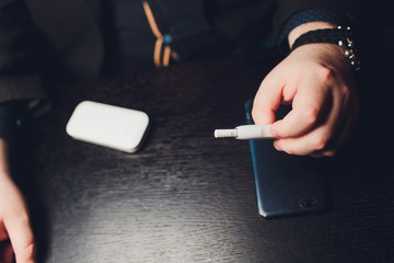 heat-not-burn tobacco product technology. Man holding e-cigarette in his hand before smoking.