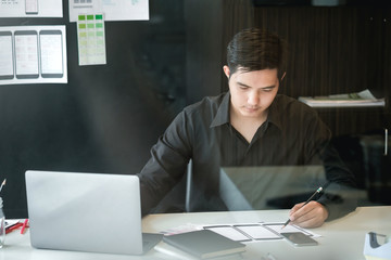 Designer man creative drawing website ux app development and application for mobile phone in the office.
