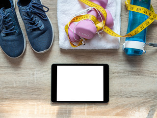 Fitness equipment with dumbbells, towel and digital tablet blank screen on isolated. Space available for advertising ro your message