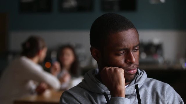 Upset african man feel lonely excluded rejected by white friends