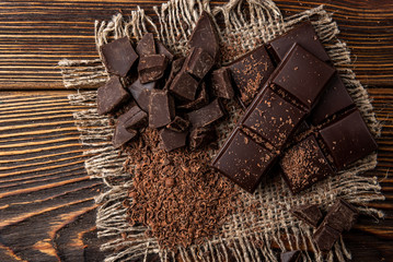 Chocolate bar and cocoa on dark wooden background.