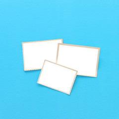 top view of blank photo frames over blue background. Top view flat lay