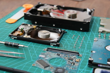 the hard drive is disassembled on the table with tools