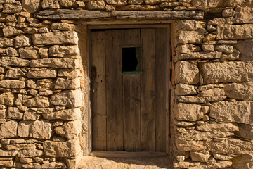 Fototapeta premium A wooden door in a stone house