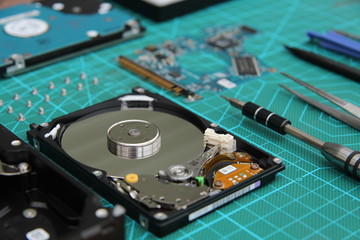Naklejka premium the hard drive is disassembled on the table with tools