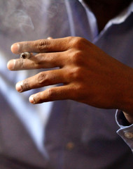 Closeup of Indian man, a smoker, hand holding cigarette