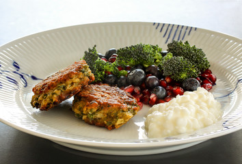 Vegetarian food. Vegetable cutlets from red lentils, onions, parsley and oatmeal. With salad of broccoli, pomegranate seeds blueberries and cottage cheese. Close-up with selective focus.