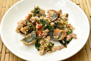 stir fried crispy basil leaf with black preserved egg and minced pork on dish