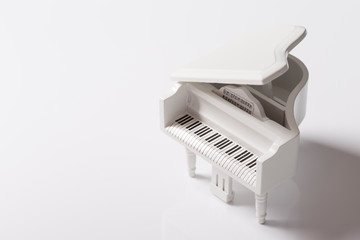 White tiny toy piano music sound on a white background