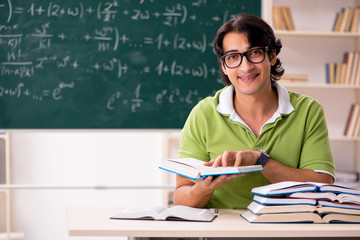 Handsome student in front of chalkboard with formulas 
