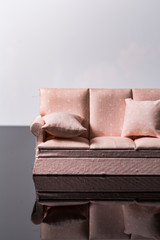Empty Pink toy sofa with pillows isolated on a black and white background