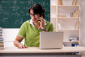 Handsome student in front of chalkboard with formulas 