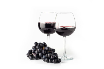 Red wine in a glass with grapes on a white background
