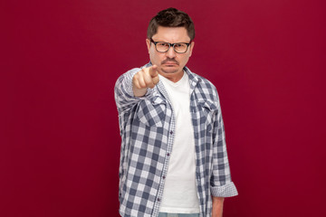 Fototapeta premium Hey you. Portrait of serious handsome middle aged business man in casual checkered shirt and eyeglasses standing, looking and pointing at camera.