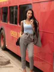 Foto op Plexiglas Jonge vrouw die zich dichtbij de rode bus van Londen bevindt - meisje dat van het leven geniet. Mooie glimlachende jonge vrouw met mooi haar in Londen, Engeland, Verenigd Koninkrijk © Delete