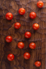 Fototapeta na wymiar Fresh tomatoes lying on carved wooden cutting board. Top view with copy space.