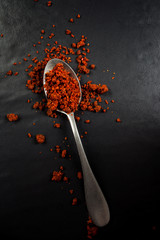 Top view of a spoon with satay powder isolated on black
