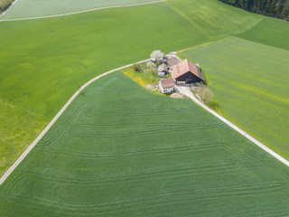 Aerial view of farm house in remote area in rural landscape in Switzerland.