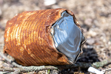Obraz premium An old, rusted tin can lying on the ground on a sunny day.