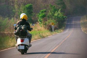 Happy couple in love on retro motorbike driving togetger and ejoying the trip in countryside, Youung couple drive motorcycle to travel.