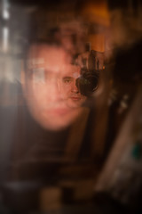 Blurred photo young attractive caucasian man photographer journalist reporter operator making selfie at mirror. Concept taking himself through mirror, reflection, self portrait, photo shot